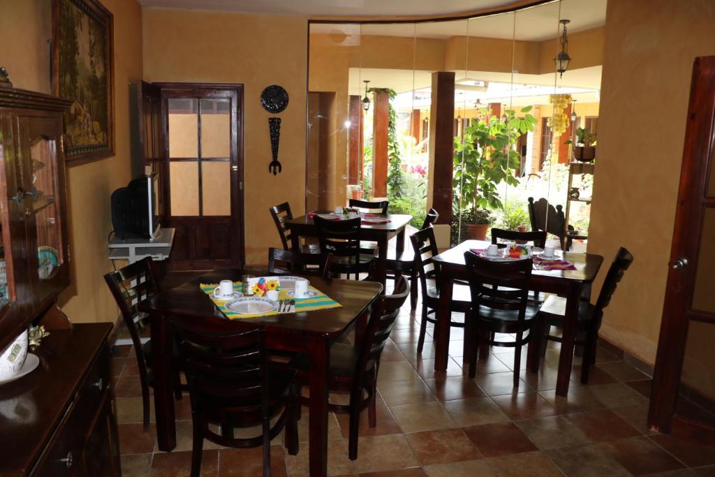 uma sala de jantar com mesas e cadeiras de madeira em Posada Gema de Copan em Santa Rosa de Copán