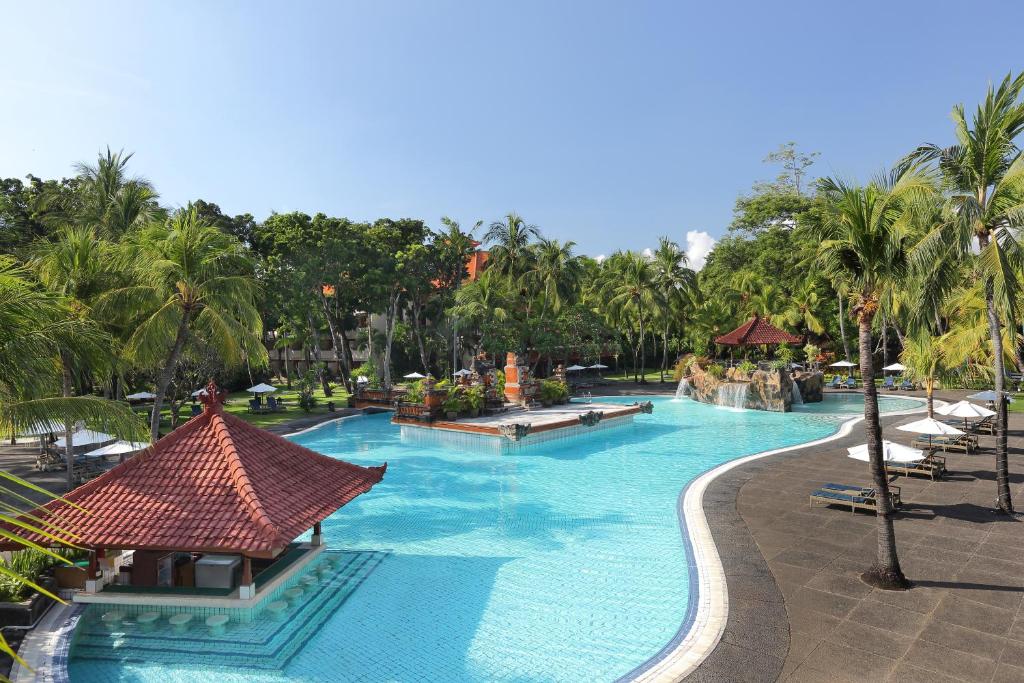 a pool at a resort with palm trees at Bintang Bali Resort in Kuta