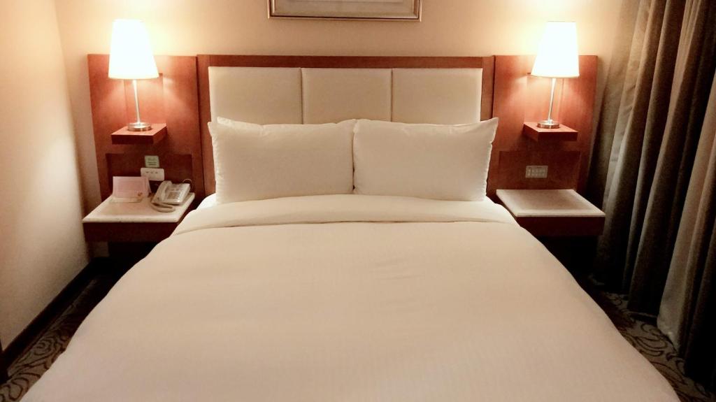 Säng eller sängar i ett rum på Elegance Hotel