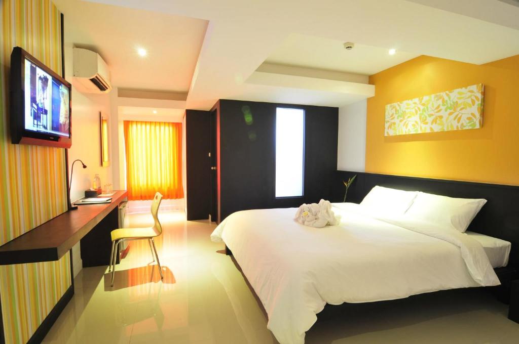 a bedroom with a bed and a desk and a television at At 24 Boutique Hotel in Nakhon Si Thammarat