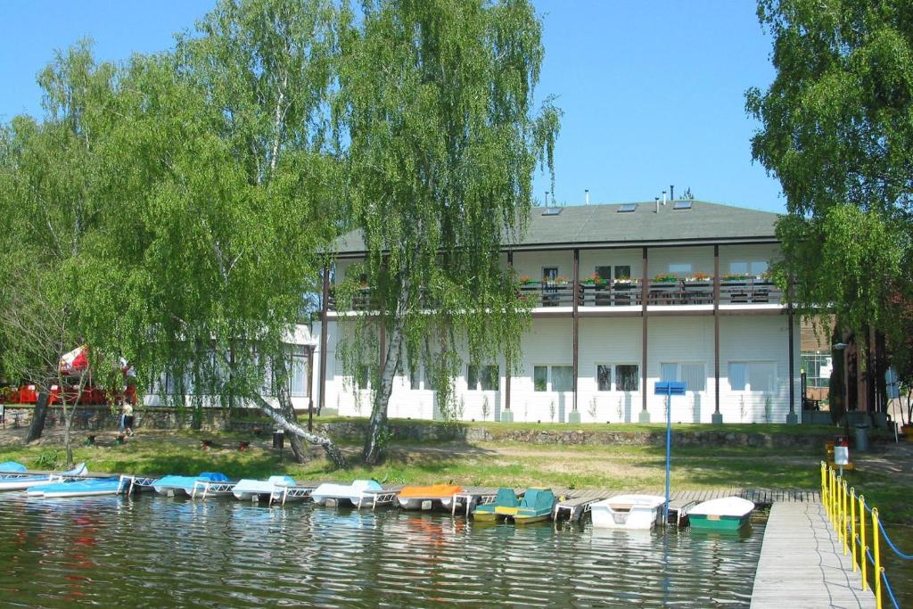 Un bâtiment avec un tas de bateaux dans l'eau dans l'établissement Ośrodek Niezamyśl, à Zaniemyśl