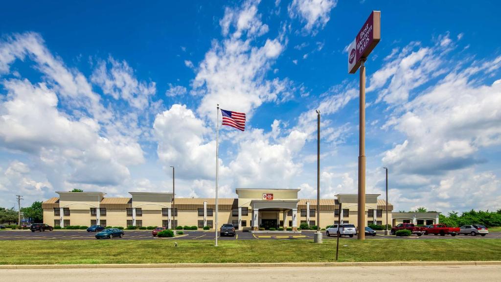 un edificio con una bandera americana en un estacionamiento en Best Western Plus Anderson, en Anderson