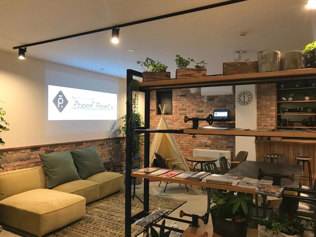 a living room with a couch and a table at Guest House Proof Point in Kushiro