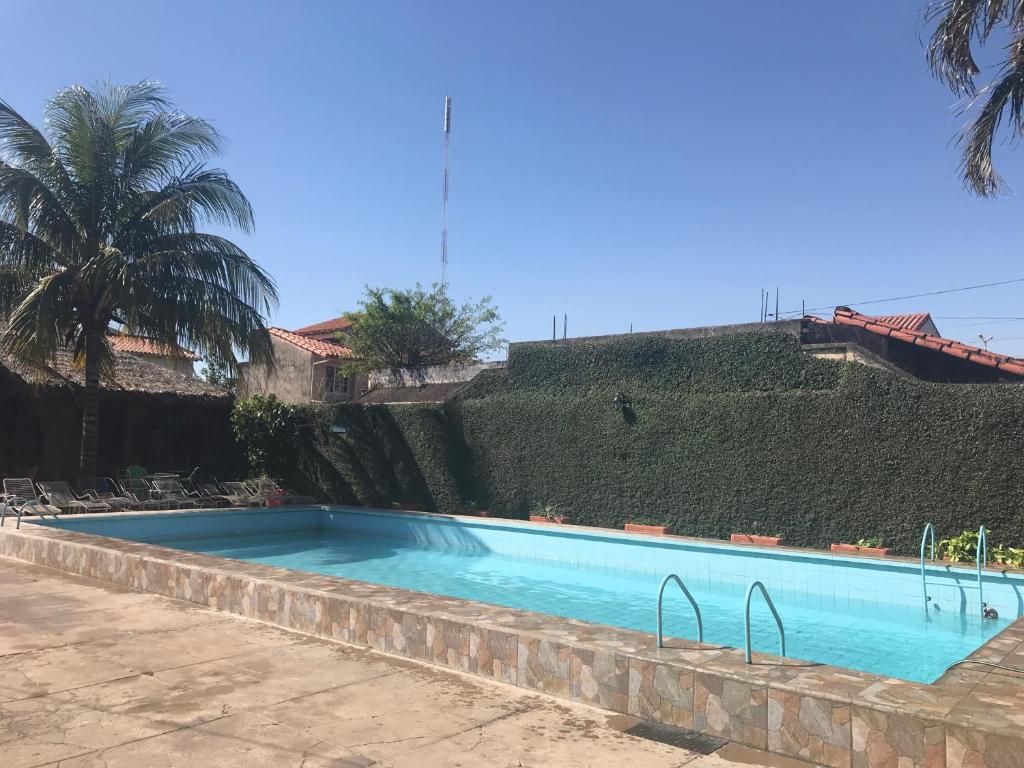 duży niebieski basen obok budynku w obiekcie Hostal Don Nabil w mieście Santa Cruz de la Sierra