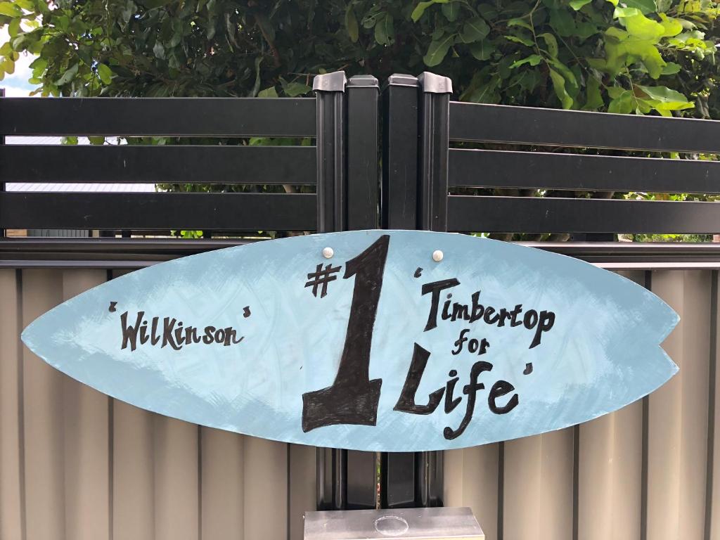 a sign with a surfboard on top of it at Timbertop for Life in Gold Coast