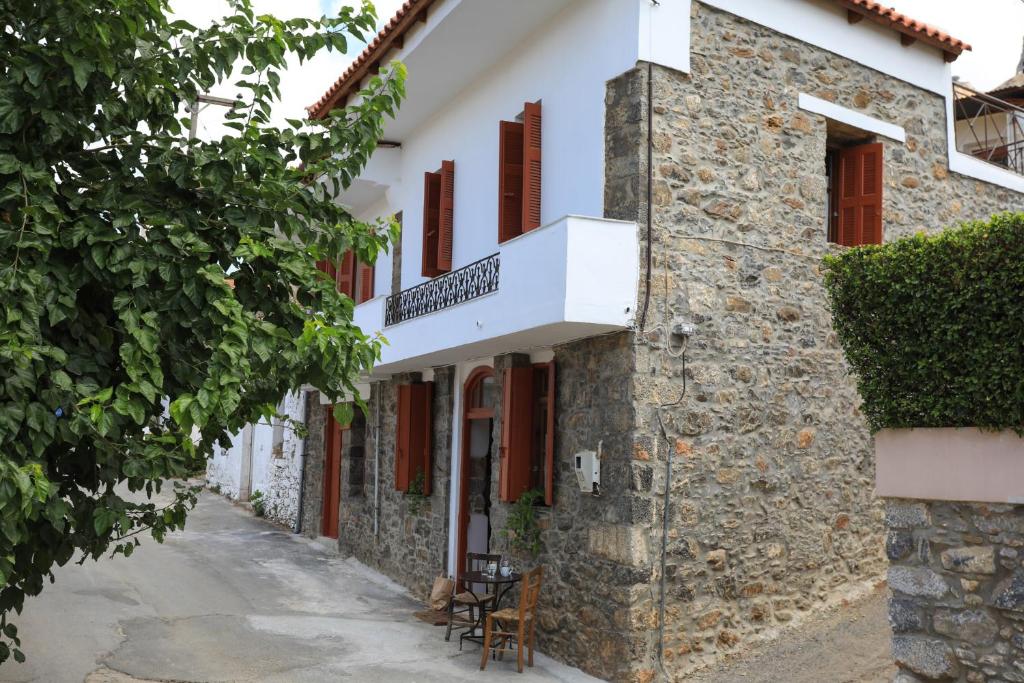 a stone building with red windows and a street at Kaldi's Traditional House in Kastamonítsa