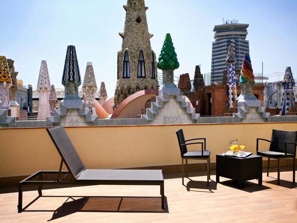 a chair and a table in front of a building at Gaudi Hotel in Barcelona