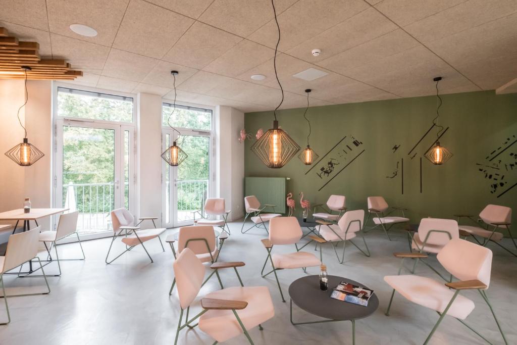 a waiting room with pink chairs and tables at Airbase Hotel in Kalsdorf bei Graz