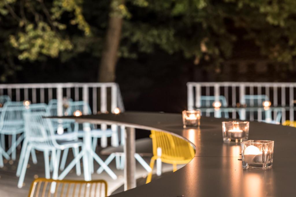 a table with candles and chairs on a patio at Airbase Hotel in Kalsdorf bei Graz