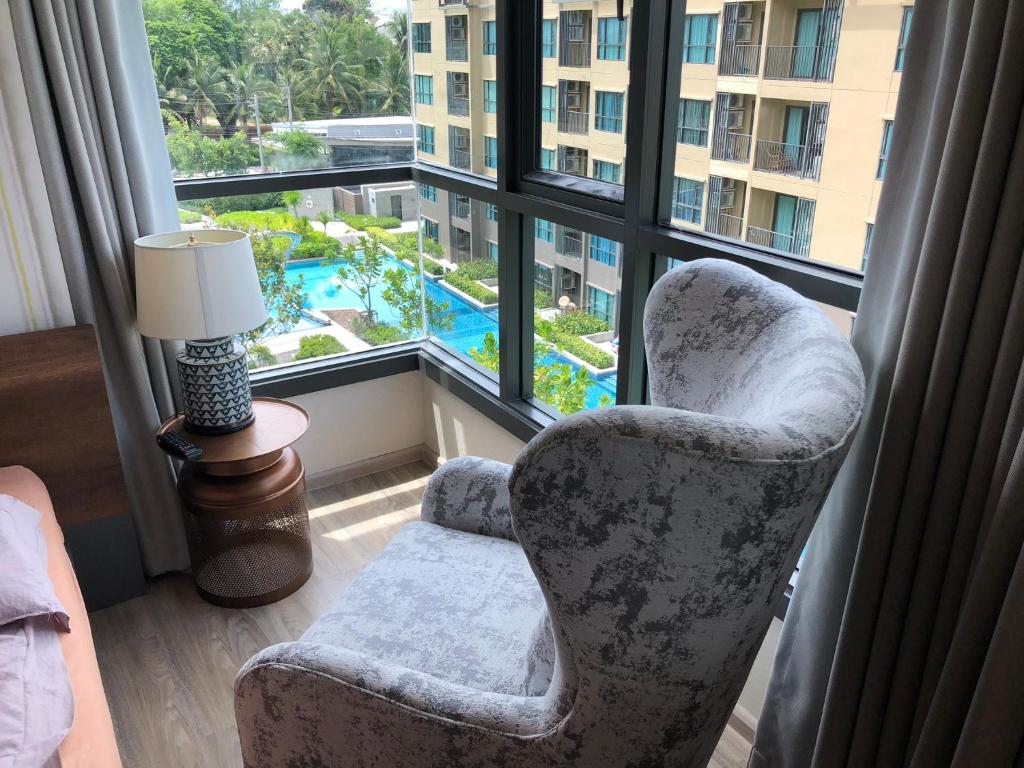 a living room with a chair and a window at rain condo Cha-am 2 bedroom by Napa in Cha Am