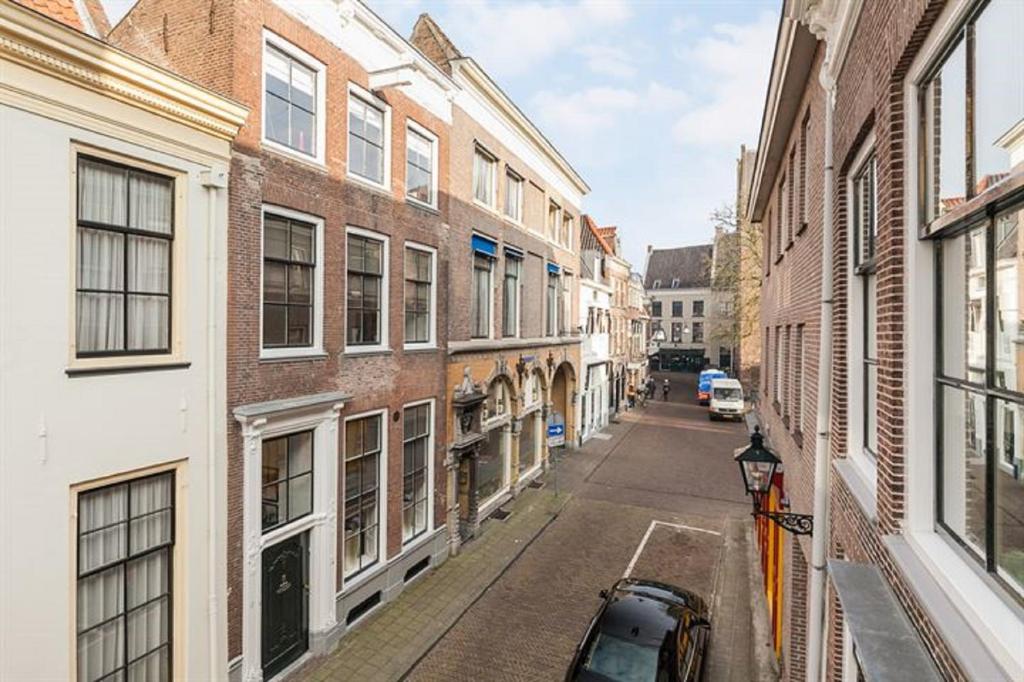 an alley with buildings and a car parked on a street at Stadslogement Bij de Sassenpoort in Zwolle