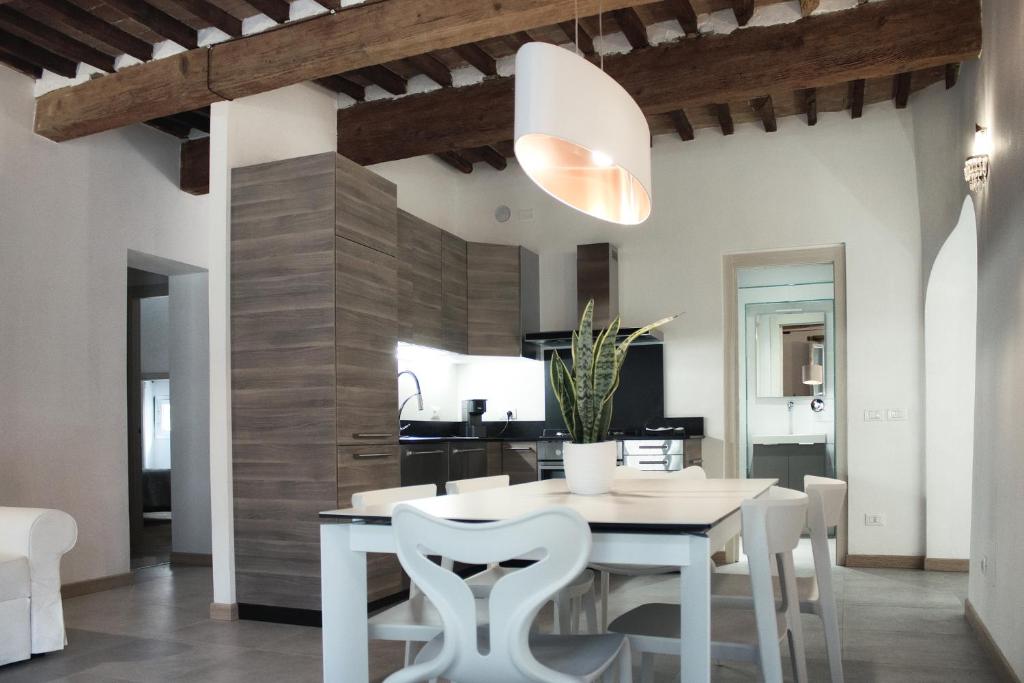 Il comprend une cuisine et une salle à manger avec une table et des chaises blanches. dans l'établissement Vicolo del Geppone, à Lucques