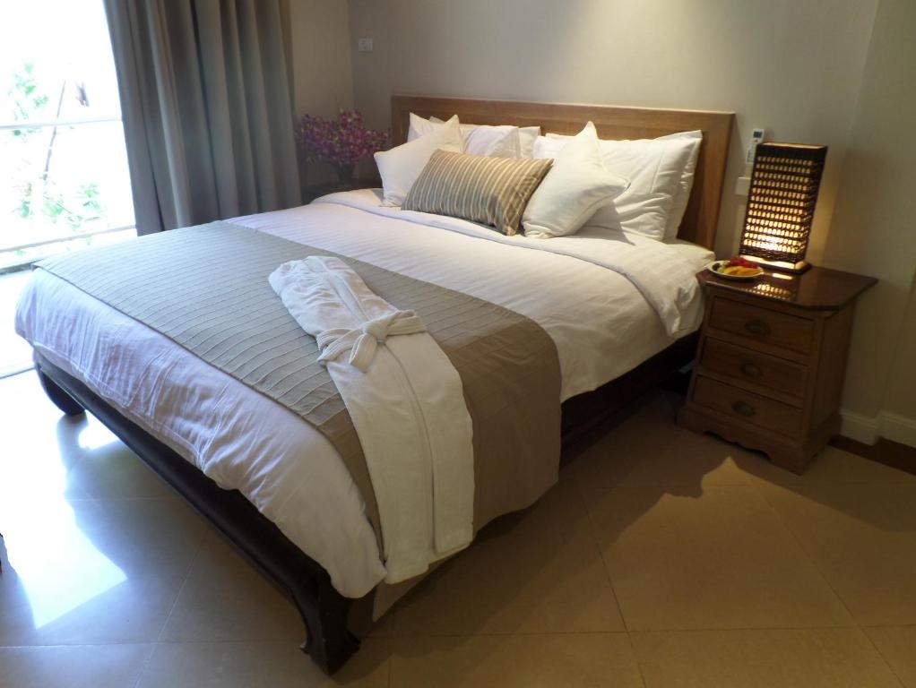 a bedroom with a large bed with a night stand at Westbury Residence in Pattaya South