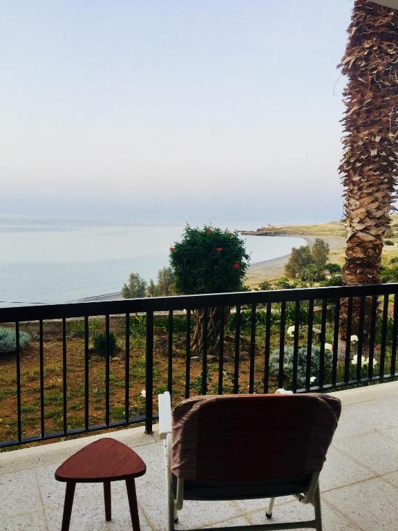 a chair and a table on a balcony overlooking the ocean at Apartment with stunning sea view in Pachyammos