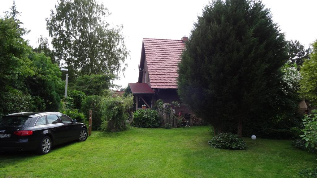 ein schwarzes Auto, das vor einem Haus parkt in der Unterkunft Ferienhaus im urigen Garten bzw Eulenhaus in Zingst