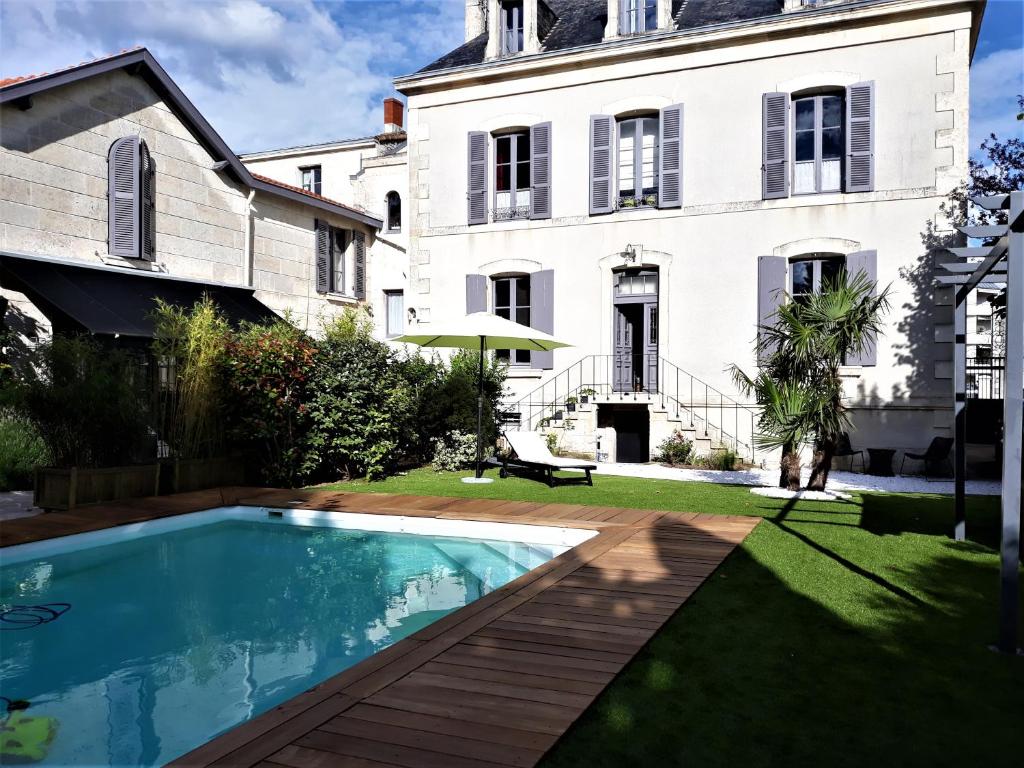 une maison avec une piscine en face d'une maison dans l'établissement Chambres d'Hôtes Maison La Porte Rouge, à Niort