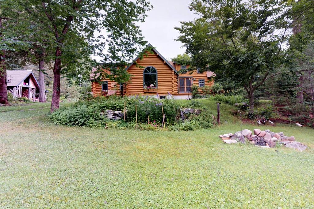 una cabaña de madera en el patio de una casa en Authentic Maine Log Cabin, en Greenville