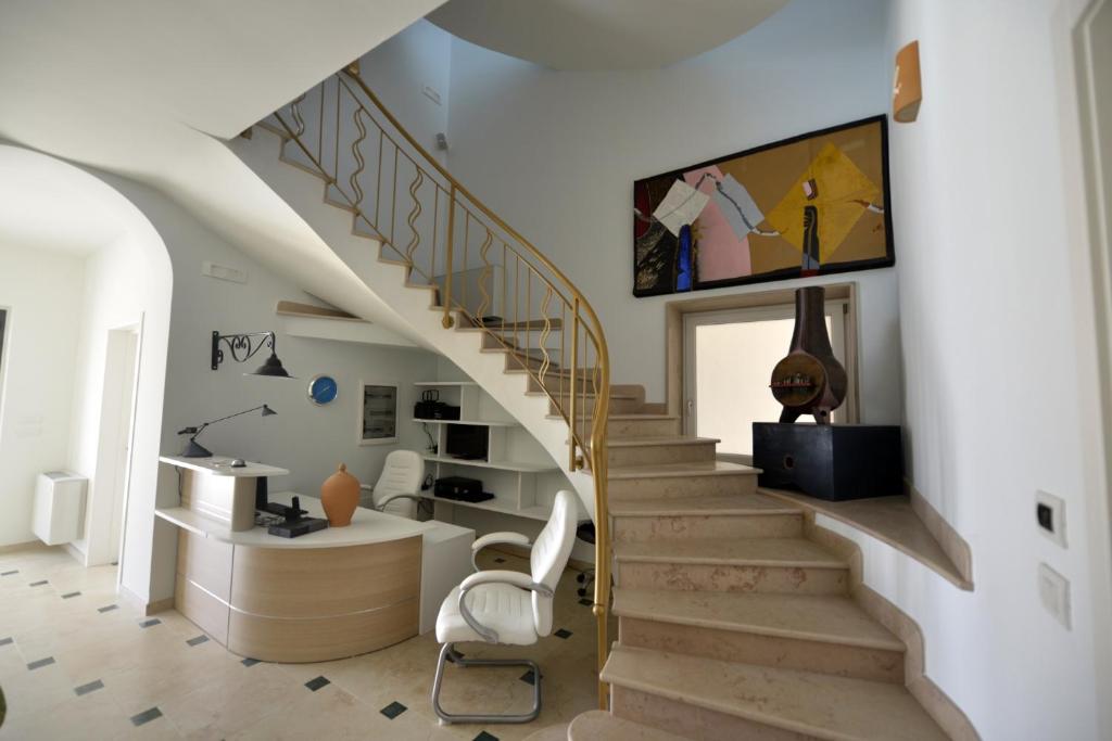 a living room with a staircase with a chair at B&B dei Ciclopi in Salice Salentino