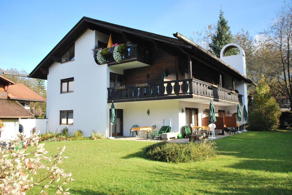 a white house with a balcony and a yard at Appartementhaus Florianshof in Garmisch-Partenkirchen