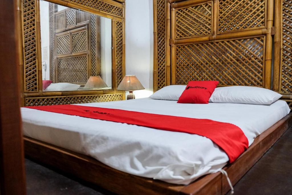 a bedroom with a bed with a red blanket at RedDoorz Plus near Jalan Baru Bogor in Bogor