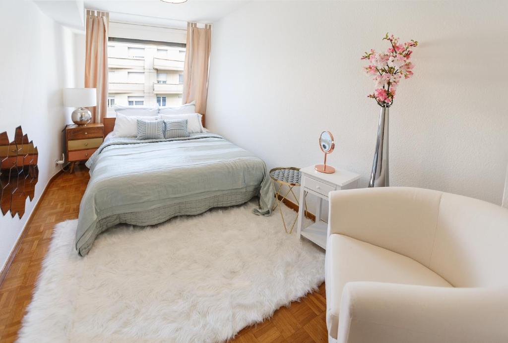 a white bedroom with a bed and a couch at Central Apartment with Terrace in Montreux