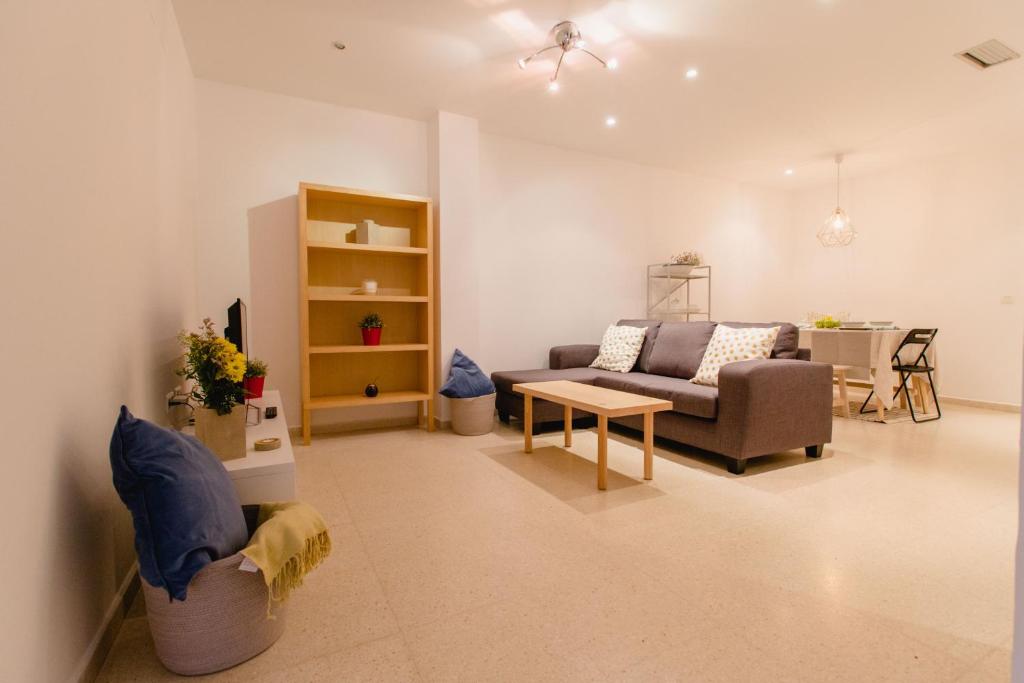 ein Wohnzimmer mit einem Sofa und einem Tisch in der Unterkunft Apartamento El Patio de Canovas in Cádiz