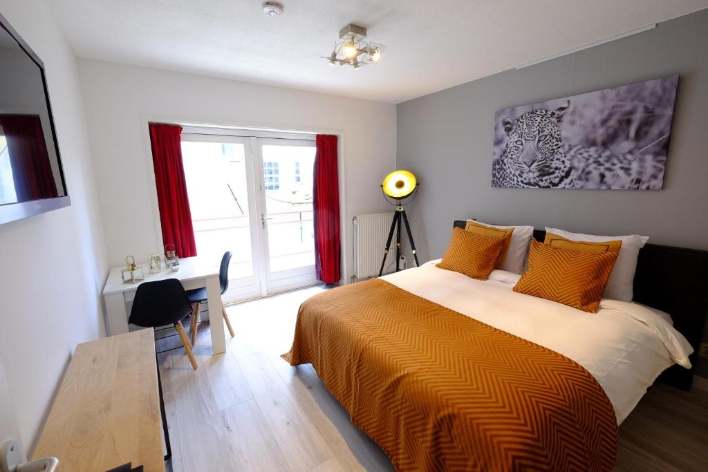 a bedroom with a bed and a desk and a window at Citycenter Residence in Amsterdam