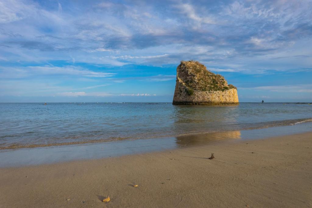a large rock in the water on a beach at Andrew'S home - Playita in Torre Pali
