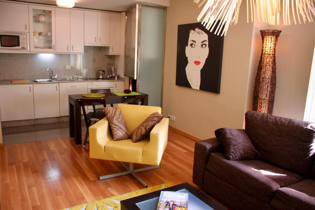 salon z kanapą i krzesłem oraz kuchnia w obiekcie RESIDENCIAL MONDARIZ BALNEARIO 123 w mieście Mondariz-Balneario
