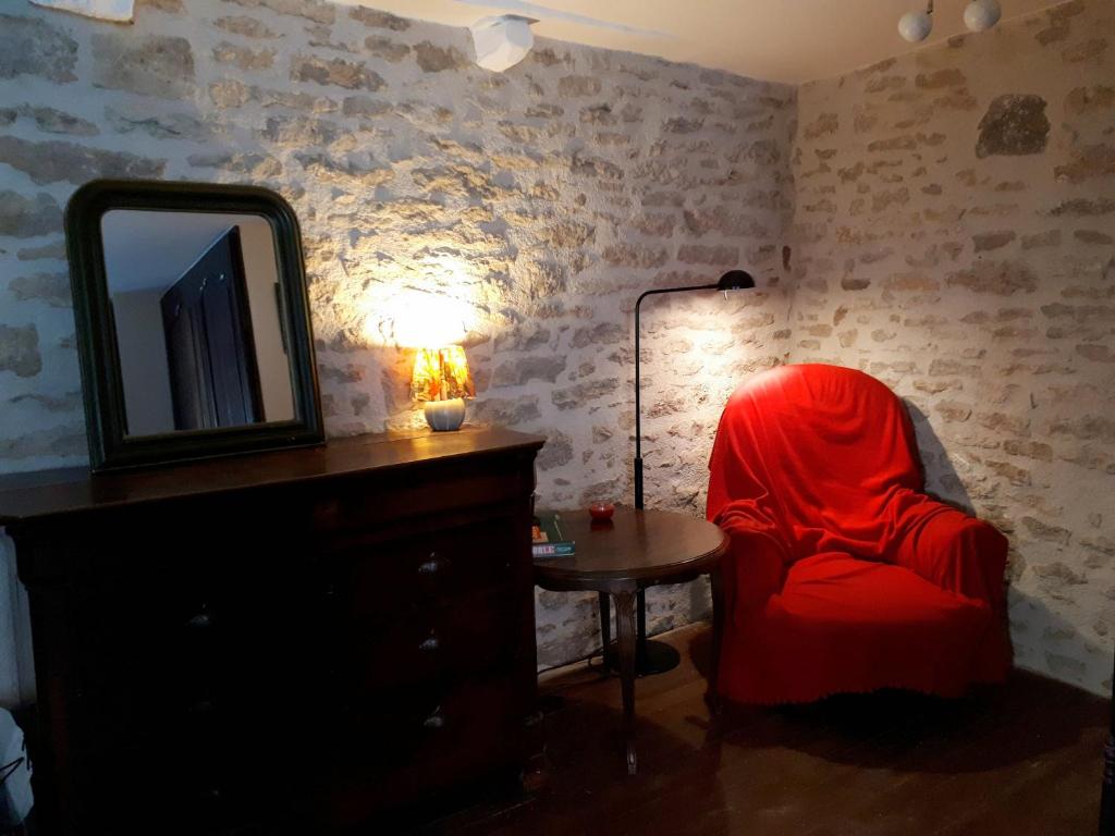 フラヴィニー・シュル・オズランにあるLa Maison de Pierreの赤い椅子と鏡付きの部屋