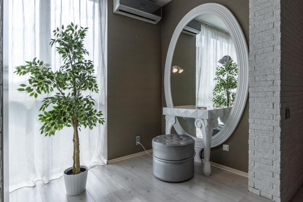 ニジニ・ノヴゴロドにあるApartment Uspekhの円形鏡と植物2本付きのバスルーム