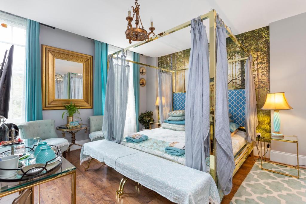 Mama’s Inn Boutique Guest House في نوتينغهام: غرفة نوم مع سرير المظلة والجدران الزرقاء