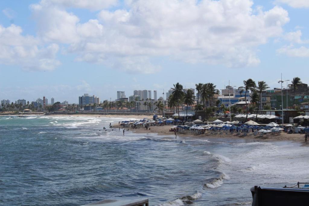 uma praia com guarda-sóis e cadeiras e o oceano em Hotel Luar de Itapua em Salvador