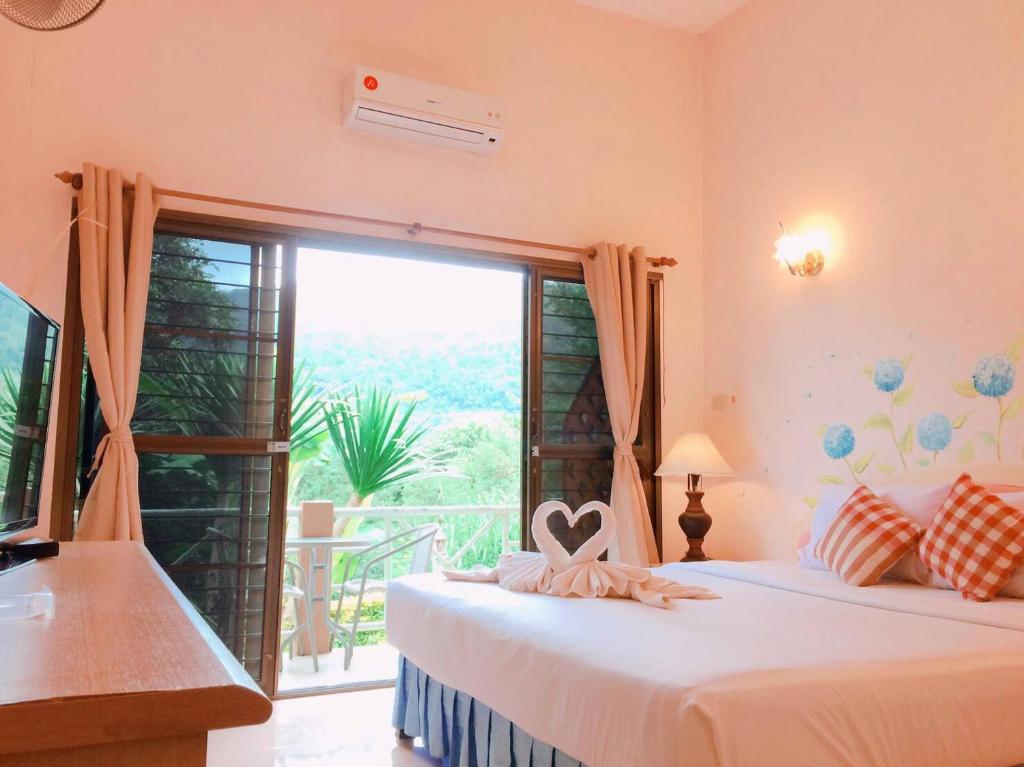 Phurua Bussaba Resort & Spa في لووي: غرفة نوم بسريرين ونافذة كبيرة