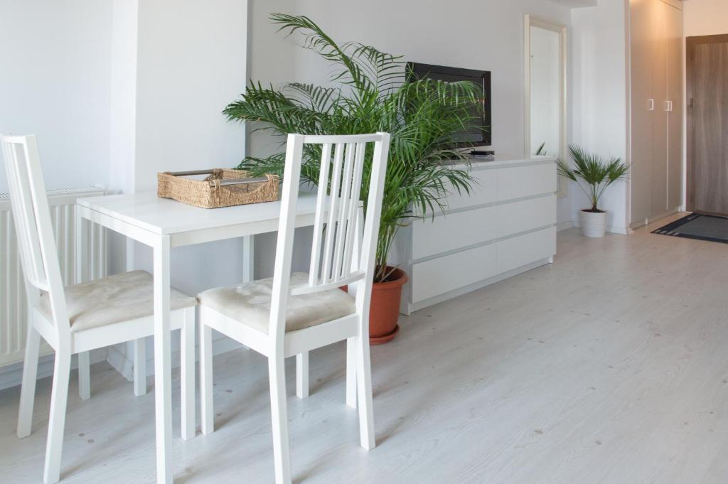 a white table and chairs in a room with a tv at Airport Residence - 5 Mins from Airport in Otopeni