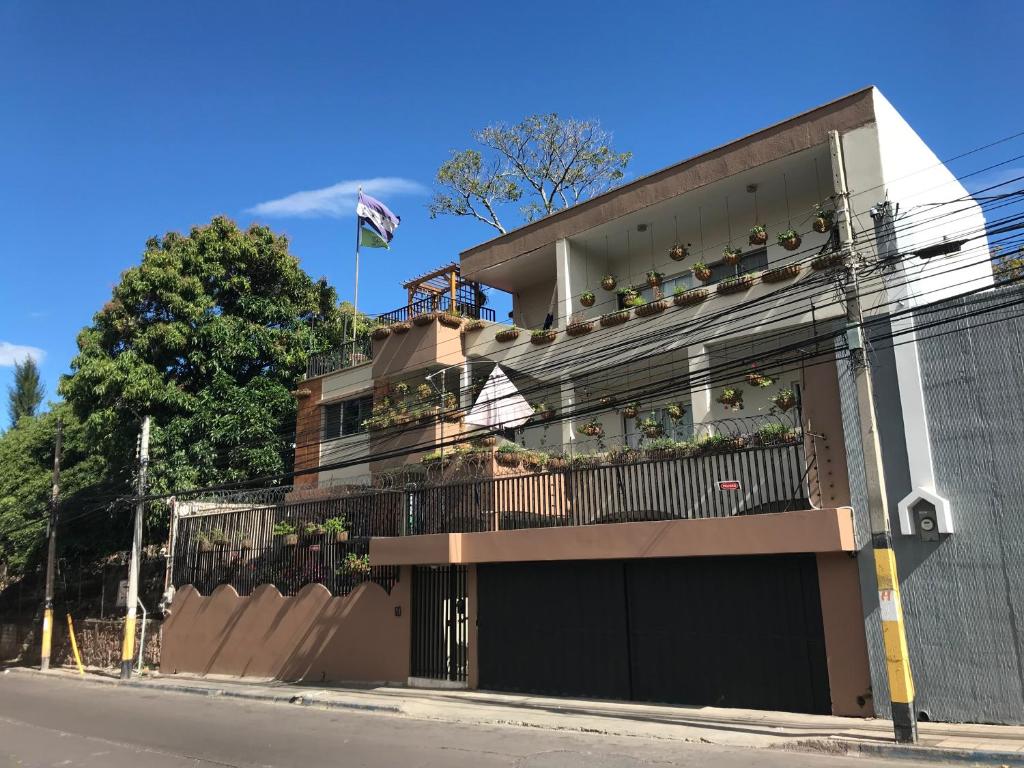a building with a balcony with plants on it at Palmira Hostel in Tegucigalpa