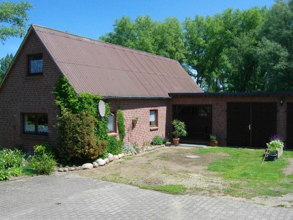 una casa de ladrillo con techo rojo y patio en Zum Froschteich, en Damnatz