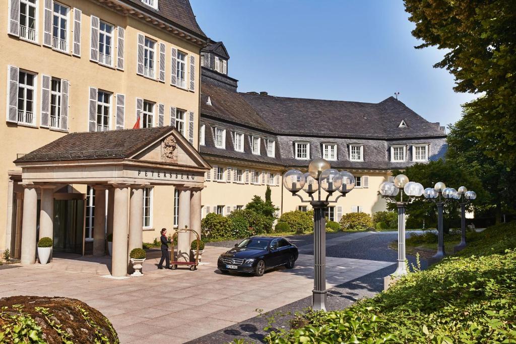 ein Auto, das vor einem Gebäude mit einem Pavillon parkt in der Unterkunft Steigenberger Grandhotel & Spa Petersberg in Königswinter