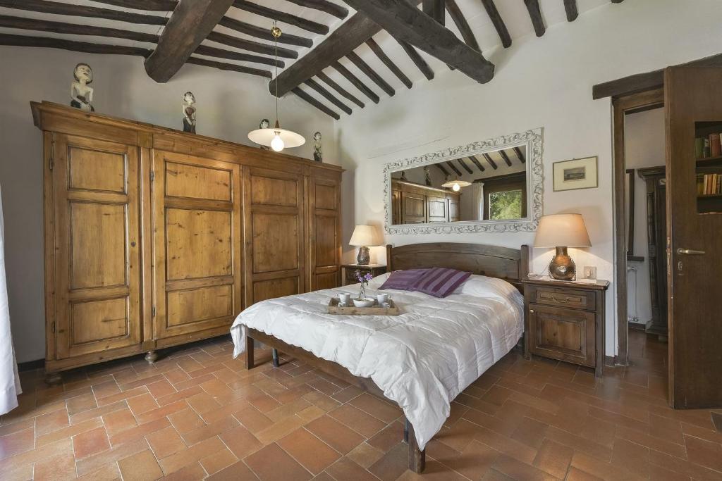 une chambre avec un grand lit et un grand miroir dans l'établissement Casale Cipressi, à Castellina in Chianti 58 autres photos