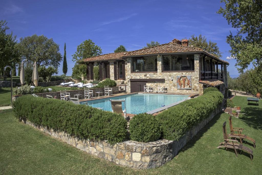 une maison avec une piscine devant dans l'établissement Casale Cipressi, à Castellina in Chianti