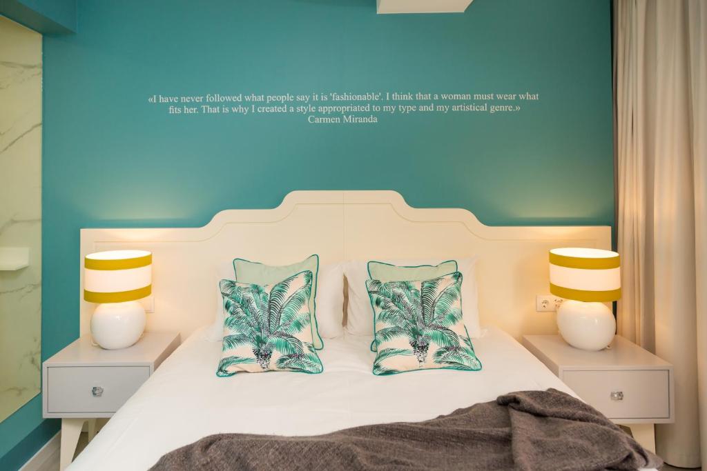 a bedroom with a bed with two lamps and two pillows at Chic Studios in Parede