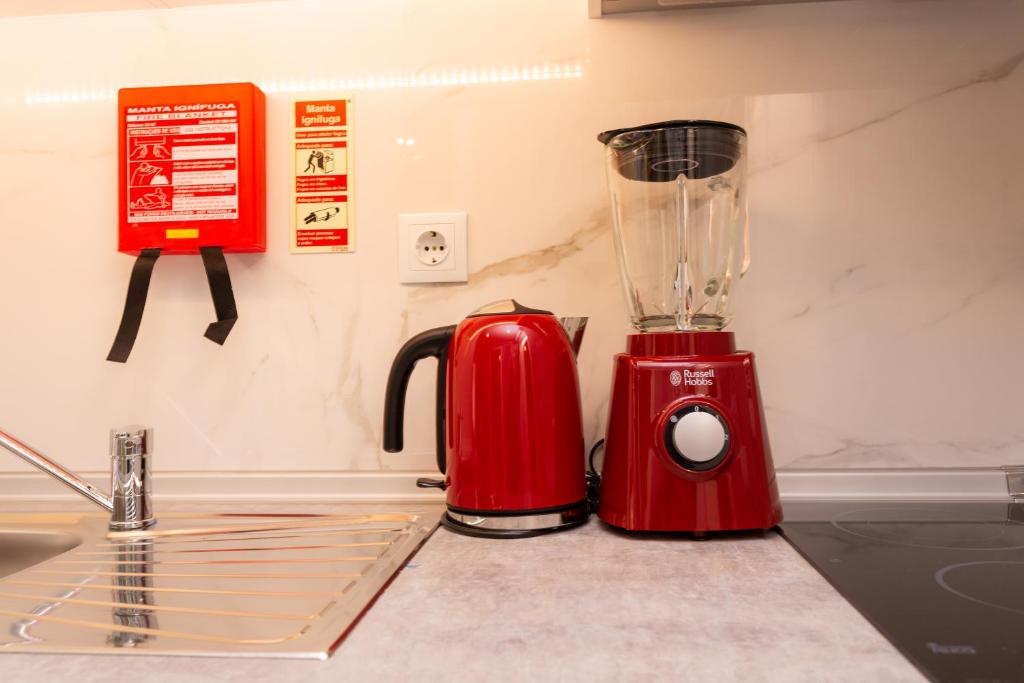 a red blender sitting on a counter next to a sink at Chic Studios in Parede