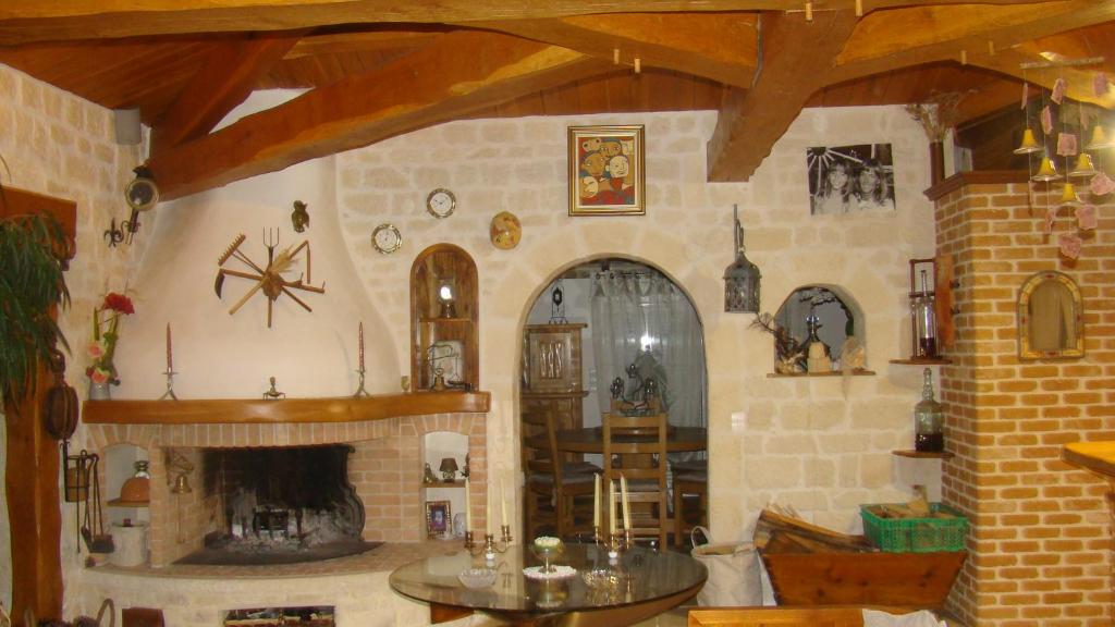 a living room with a fireplace and a table at Le Mas des Mathes, Chambres d&#39;hôtes, Studios in Les Mathes