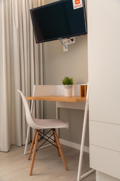 a desk with a computer monitor and a chair at Chic Studios in Parede