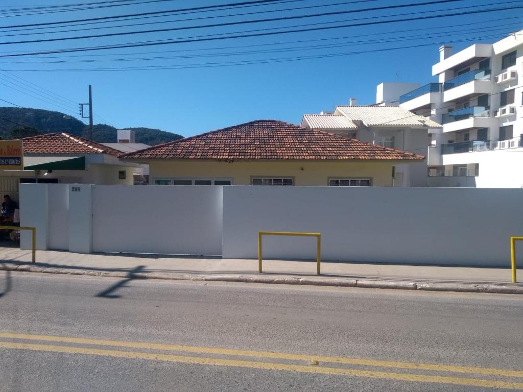 una pared blanca al lado de una calle con edificios en Casa 6 pessoas 100m do mar 010, en Florianópolis