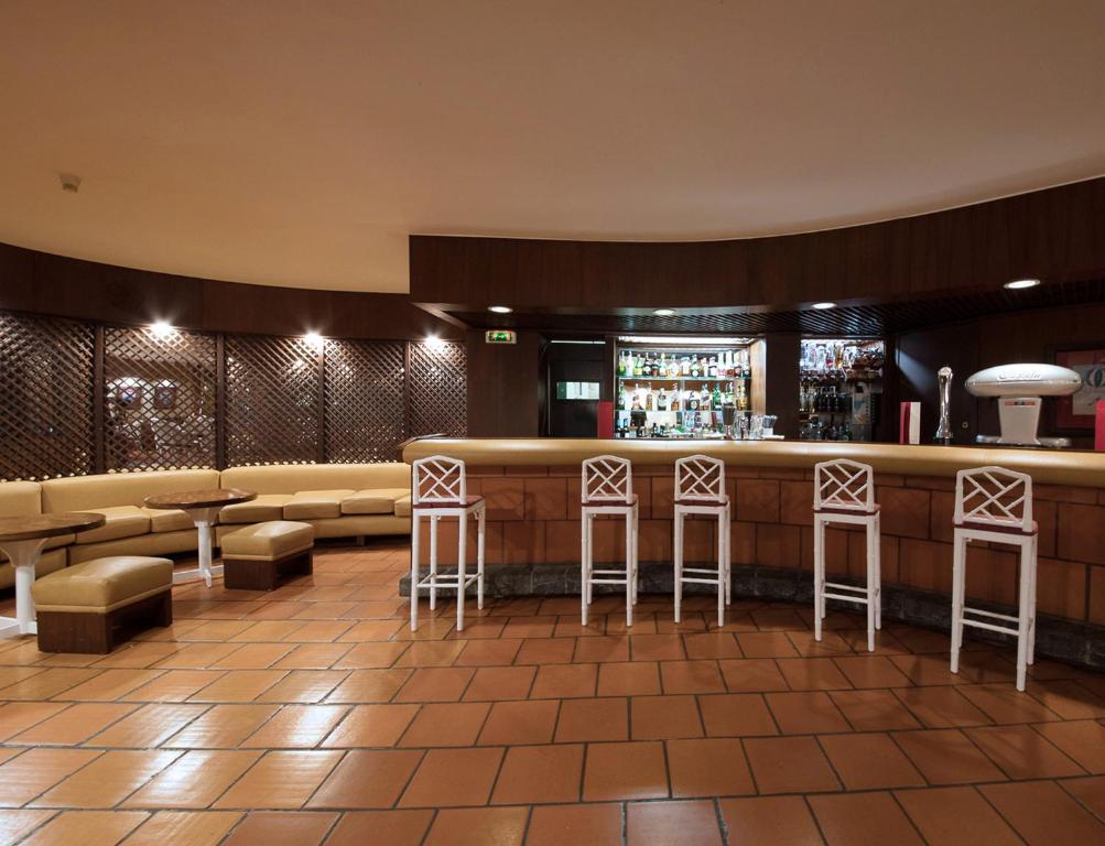 a bar in a restaurant with stools at Dom Pedro Madeira in Machico