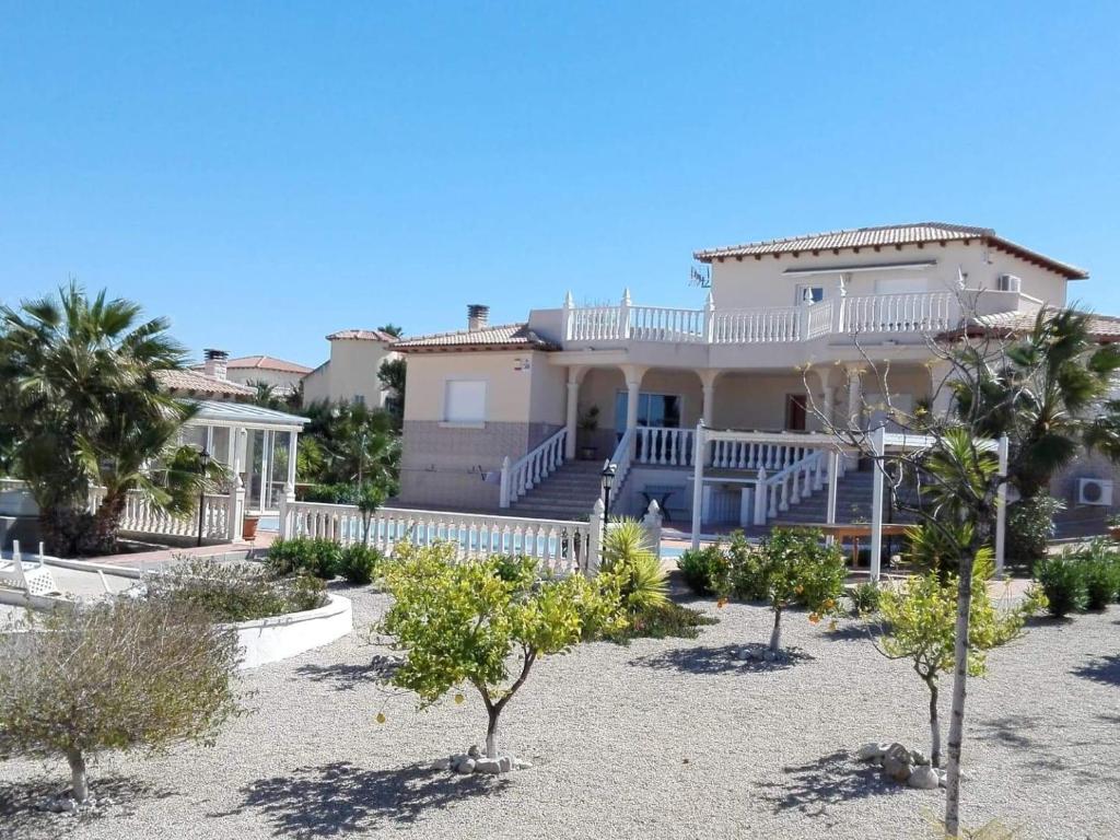 a large white house with palm trees in front of it at Villa del Rio in Campos del Río