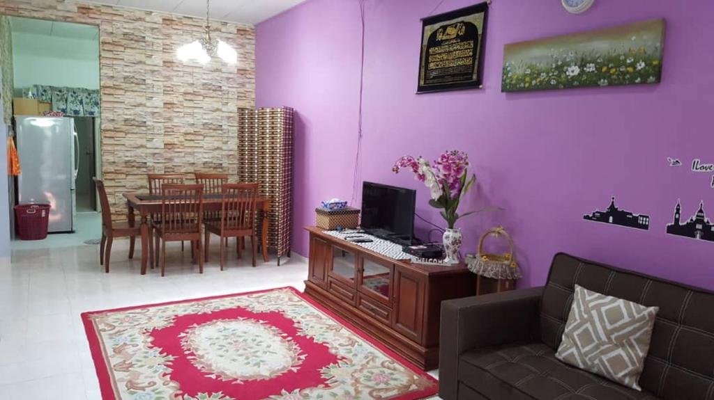a living room with a couch and a desk with a computer at Homestay De MITC Melaka in Melaka