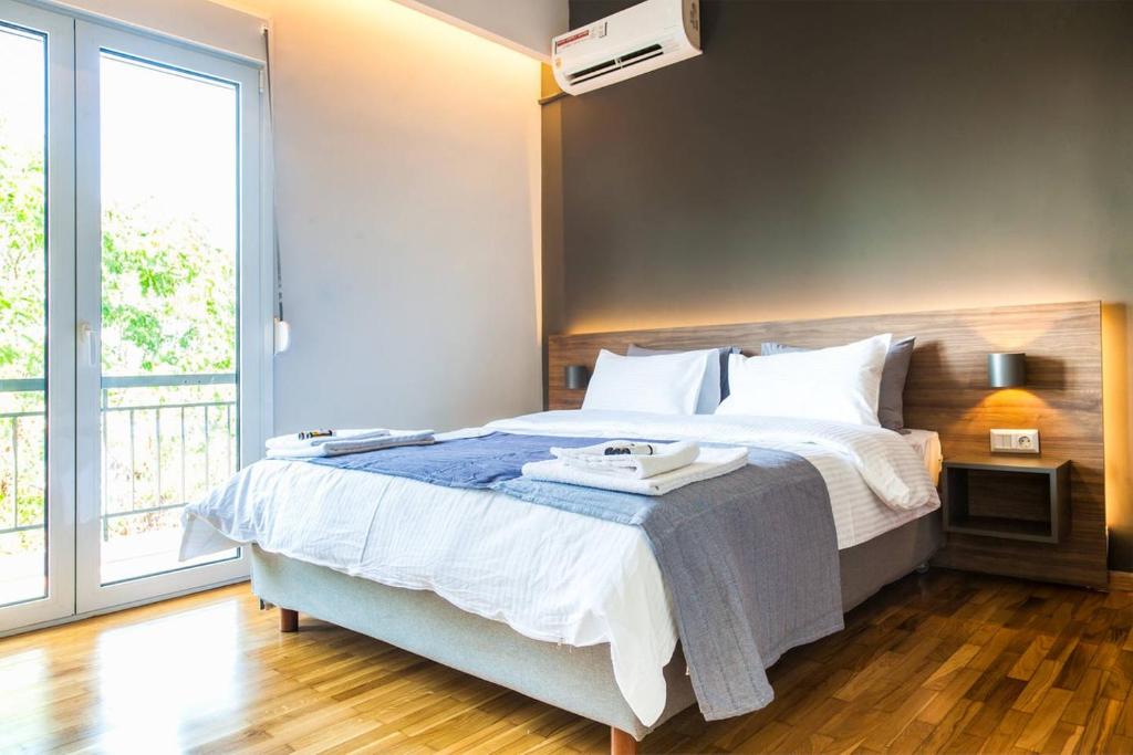 1 dormitorio con cama grande y ventana grande en TONI'S Comfy 3BD home with patio, close to Metro en Atenas