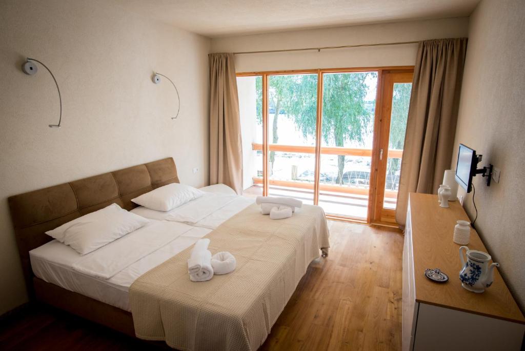 a hotel room with a bed with towels on it at Living In Delta - Casa de vacanta in Crisan